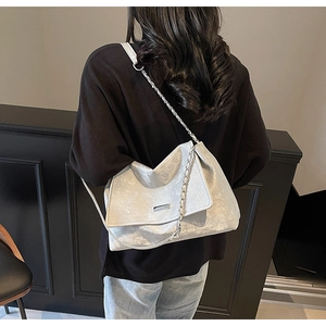 Vue détaillée du sac cabas argenté métallisé avec texture plissée et chaîne chic