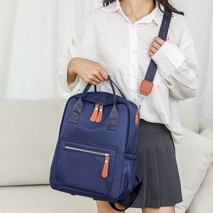 Détail d'un sac à dos en nylon bleu foncé avec finitions en cuir sur mannequin