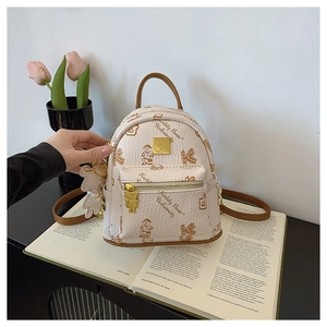 Detailed macro view of the embossed leather texture and cute teddy bear logo on the backpack