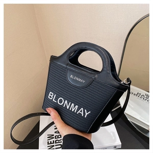 Detalle del bolso BLONMAY tejido con bordado de logo blanco y acabados en cuero