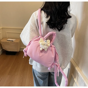 Detail of pink padded drawstring backpack with cute plush wing charm and wide straps
