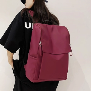 Vue latérale d'un sac à dos bordeaux haute capacité pour ordinateur et voyage décontracté