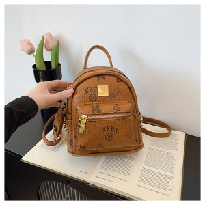 Close-up of brown faux leather mini backpack with bear pattern and gold hardware