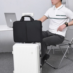 Gros plan d'une sacoche d'ordinateur noire sur une valise avec des poches zippées pratiques