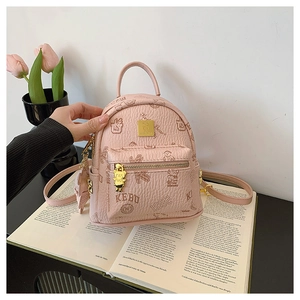 Close-up of pink mini backpack with bear print and golden metal logo hardware