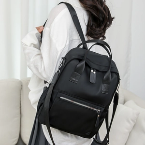 Détail du sac à dos en nylon noir avec poche zippée et bretelles réglables confortables