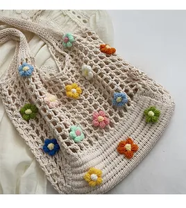 Dettaglio della borsa tote beige all'uncinetto con fiori 3D fatti a mano e maglia fitta