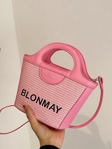 Bolso cubo de paja rosa con asa superior y correa cruzada mostrado en una vista de mano
