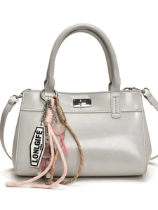 Sac fourre-tout gris clair en cuir avec fermoir rotatif et pendentifs décoratifs