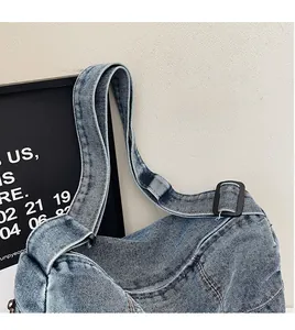 Detail of adjustable denim shoulder strap with black metal buckle on retro blue tote bag