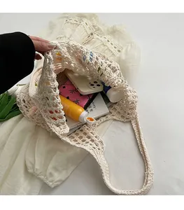 Vista dettagliata di una grande borsa tote in maglia crema con interno spazioso