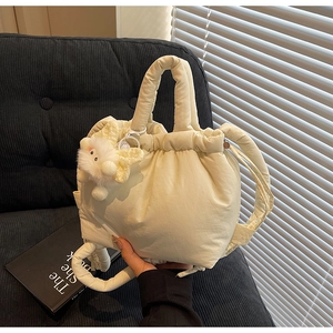 Close-up of fluffy cream bucket bag with drawstring closure and plush cloud charm