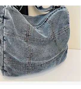 Detail of vintage denim tote bag showing blue patchwork fabric and contrast stitching