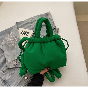 Detail of vibrant green quilted bucket bag with drawstring closure and knotted handle