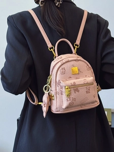 Pink mini backpack with bear print and gold hardware shown on a model in a back view