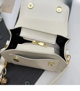Detail view of cream PU crossbody bag featuring dual magnetic clasps and smooth gold zipper