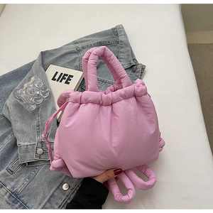 Detailed view of pink quilted fabric texture and knotted drawstring design on a bucket bag