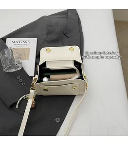 Detail view of the spacious interior compartment of this white leather crossbody bag