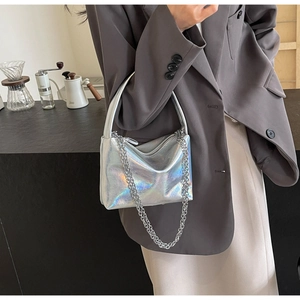 Holographic PU leather pillow bag with silver chain strap shown on a model