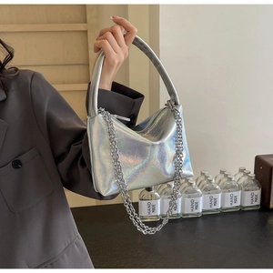 Detail of silver holographic underarm bag with rainbow luster and metallic chain strap