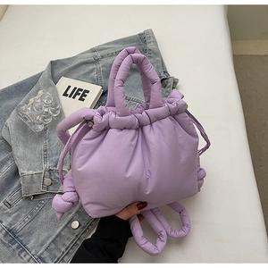 Close-up of purple quilted bucket bag featuring a padded handle and drawstring closure