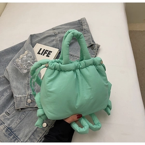 Top view of mint green quilted puffy bucket bag with drawstring and metal accents