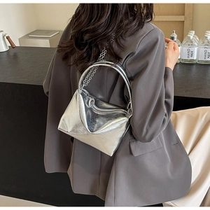 Detail view of the silver metallic chain bag showing its size and texture on a model