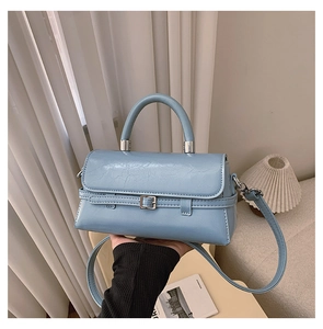 Detail of light blue wrinkled texture handbag with silver hardware and top handle