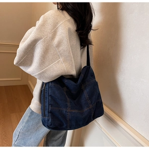 Detail view of large dark blue denim tote bag with quilted stitching for daily commute