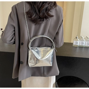 Silver metallic underarm bag with rigid semi-circular handle and chain on shoulder