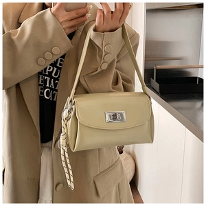 Mannequin portant un sac à main minimaliste vert crème avec fermoir rotatif argenté