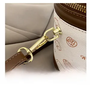 Détails des crochets dorés et finitions en cuir marron sur le sac seau blanc chic