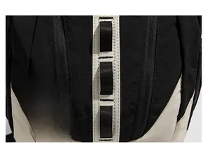 Gros plan des sangles en nylon et des doubles fermetures d'un sac à dos bicolore