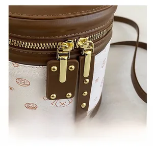 Détail de la double fermeture éclair dorée et motifs de chiens sur un mini sac seau