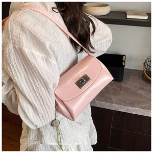 Gros plan du sac sous le bras en cuir PU rose brillant avec fermoir rotatif argenté
