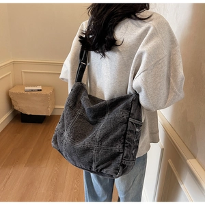Detail of vintage black denim tote bag featuring white contrast stitching and large capacity