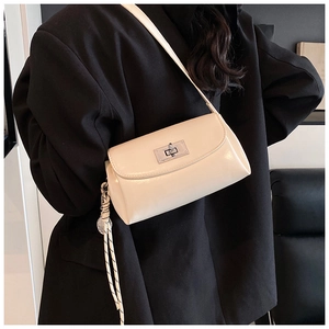 Détail d'un sac baguette en cuir crème avec un fermoir rotatif rectangulaire argenté