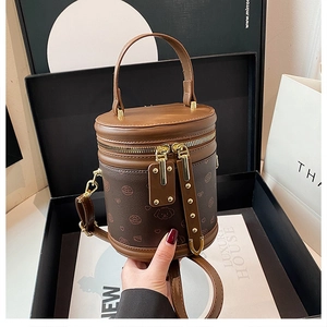 Détail d'un sac seau cylindrique marron avec imprimés mignons et garnitures dorées