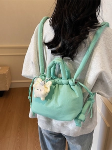 Mint green padded bucket backpack with drawstring closure and plush pendant for women