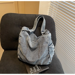 Detailed macro view of retro washed denim tote bag with frayed fringe and stitching details