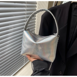 Detailed view of silver holographic pillow bag with pleated leather and metal chain