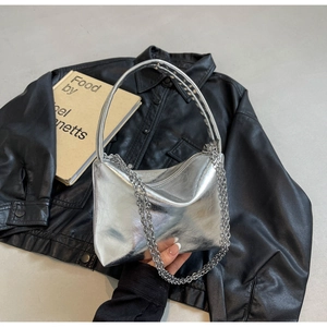 Close-up of metallic silver chain bag with crinkled texture and rivet handle detail