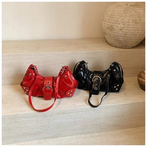 Detail view of red and black leather hobo bags with metal buckles and silver rivets