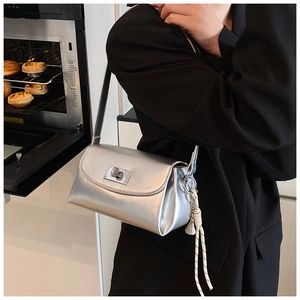 Détail du sac bandoulière argenté métallisé avec fermoir rectangulaire et pompon à nœud