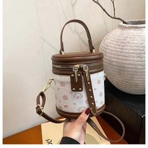 Détail d'un sac seau cylindrique marron et blanc avec motifs de chiots et cœurs mignons