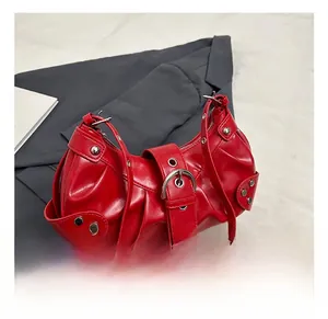 Detail of red leather shoulder bag with metallic buckle, rivets and pleated texture