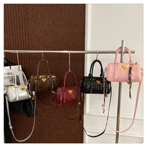Detail of five stylish Boston bags hanging on a rack in multiple trendy colors