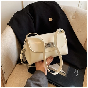 Détail du sac à main en cuir crème avec fermoir rotatif argenté et gland tressé