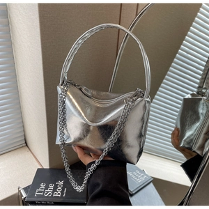 Detailed view of silver metallic pillow bag with thick chain and curved handle