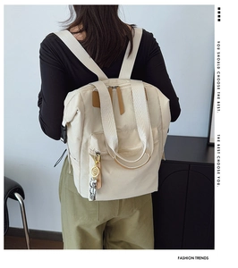 Vista trasera de una modelo con la mochila de nailon beige con asas tejidas y cremallera